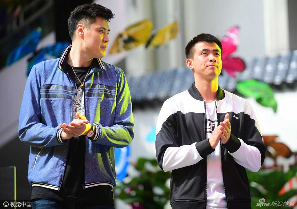 赵继伟与贺天举并肩步入会场，两人都穿着休闲便装，脸上挂着灿烂的笑容，赵继伟眼神灵动，贺天举则显得沉稳帅气，举手投足间默契十足，仿佛一对亲兄弟在自家后院闲聊。