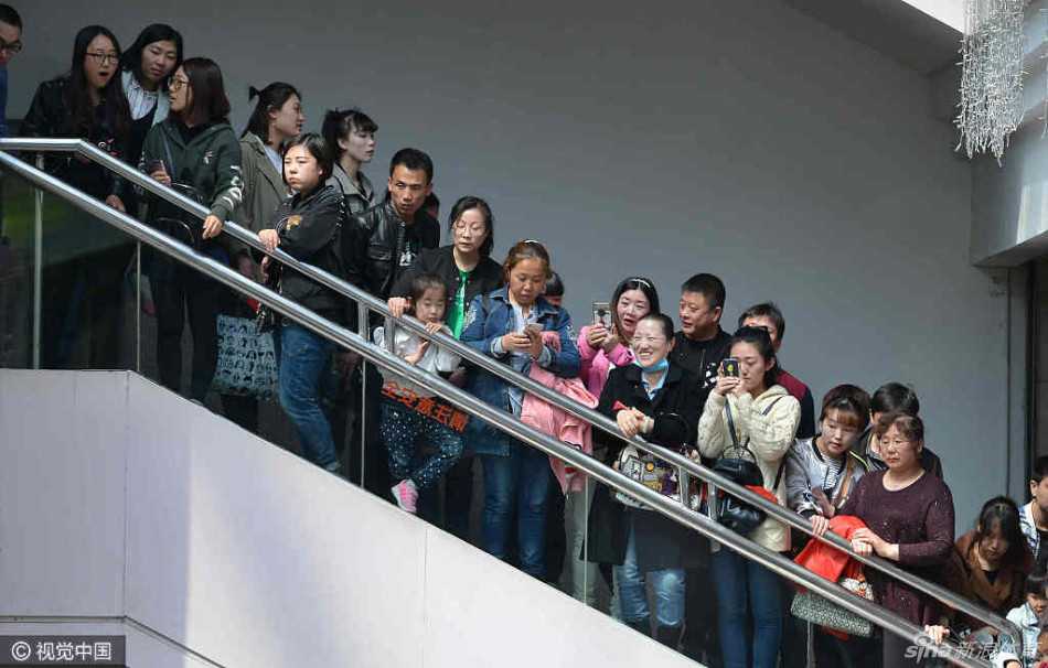 贺天举双手抱胸站在展板前，面带标志性的微笑聆听球迷提问，经历了伤病的磨砺后，他的眼神依旧坚定而温暖，身着简单T恤也难掩职业球员的挺拔身姿。