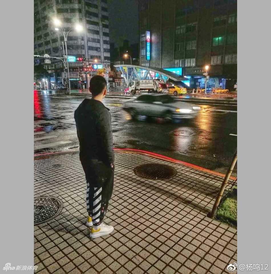 赵继伟在热闹的台北夜市留下酷炫身影，双手指天，背后是熙熙攘攘的人群和闪烁的霓虹，这一刻他不再是赛场上的指挥官，而是一个享受假期的阳光大男孩。