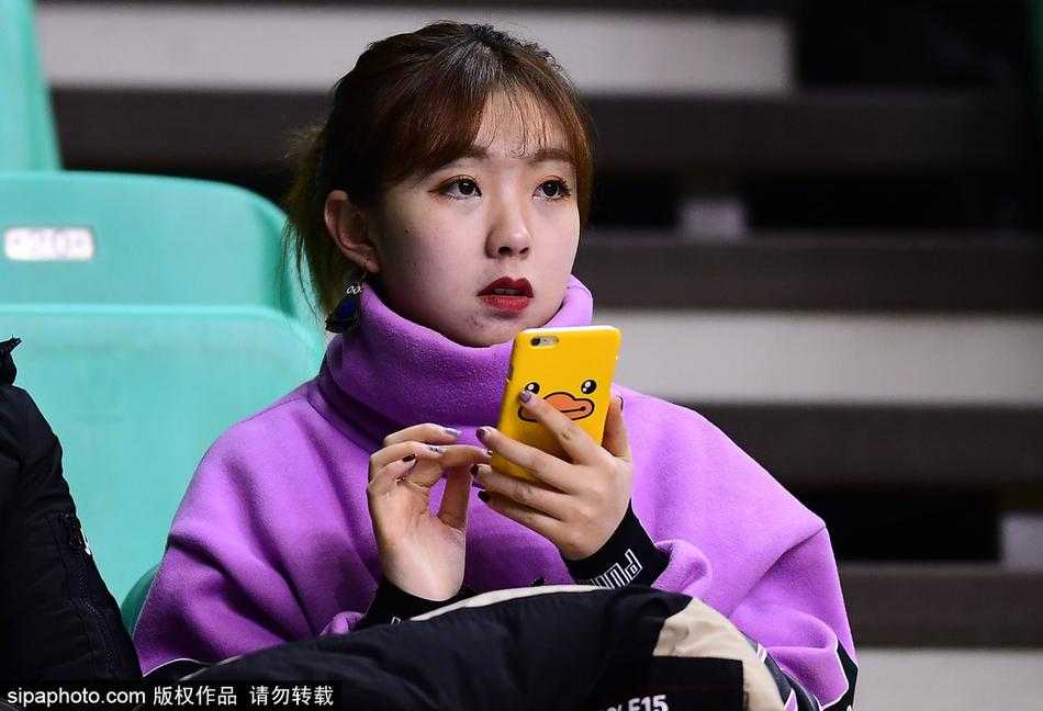 特写镜头下，这位美女球迷肌肤胜雪，她双手举着辽宁队的助威围巾，轻轻捂住口鼻，眉眼弯弯，笑意盈盈，仿佛在与场上奋战的球员进行无声的交流。