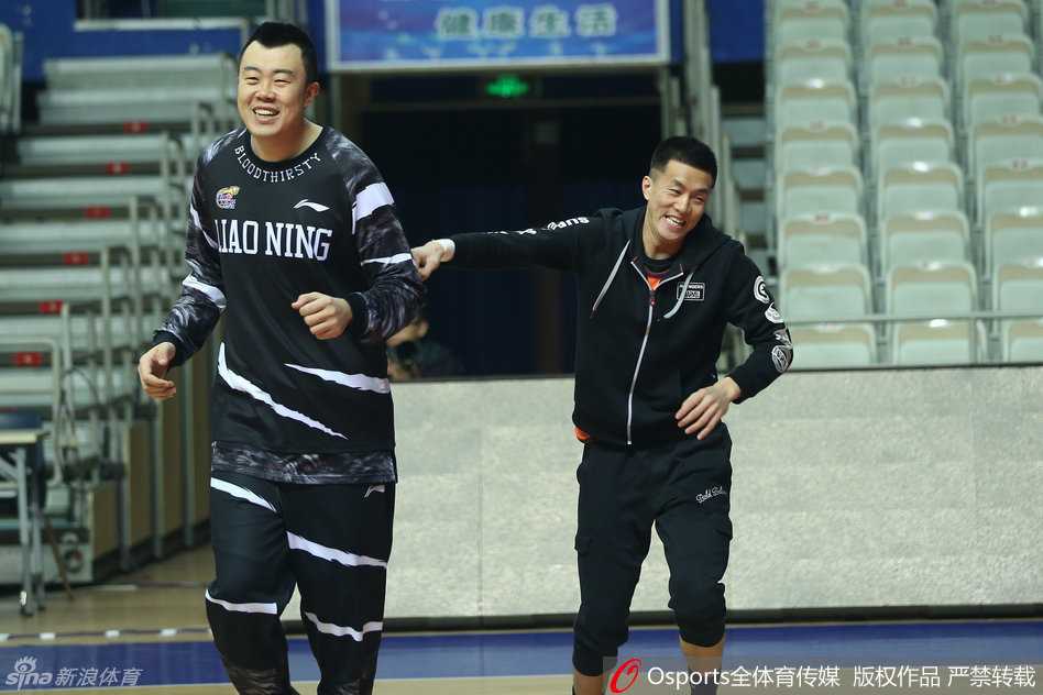 队长杨鸣双手叉腰站在场边指挥若定，俊朗的面容和挺拔的身姿格外引人注目，他正认真观察着队友们的训练状态。