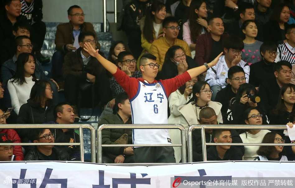 辽宁美女球迷面对镜头露出甜美可爱的表情，手拿助威棒，眼神中充满了对辽宁男篮的支持与期待，青春活力十足。