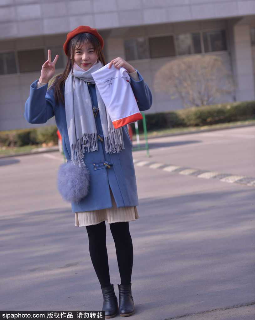 刚刚拿到签名的女球迷如获至宝，兴奋地与身边的朋友分享喜悦，低头仔细端详着刚刚签下的名字，脸上绽放出灿烂的笑容。