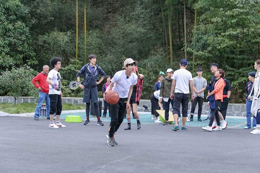 追风少年王源:篮球场上挥洒汗水,青春旅社尽显活力本色 王源在球场上大步流星地运球突破,白色T恤被汗水浸透贴在身上,卡其色帽子下的侧脸轮廓分明,充满了少年特有的力量美感。