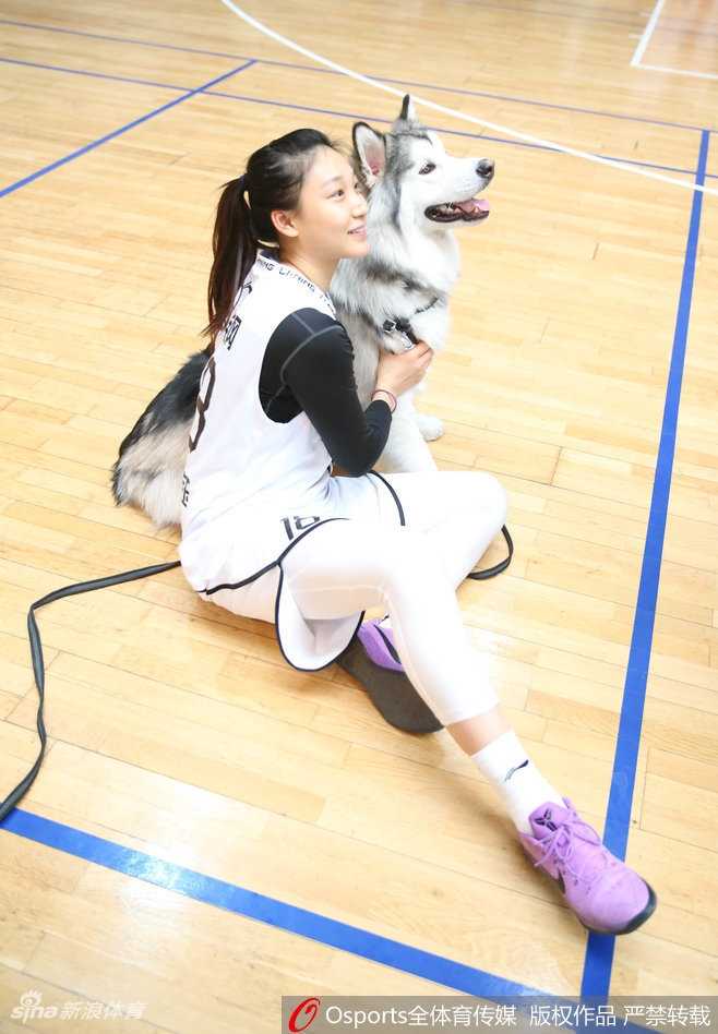 高颂单手托起懵懂小狗，眼神里满是好奇与宠溺，如同她在篮下精准地托起篮球，轻松写意。