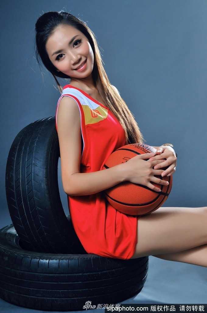 钟苑庄扎起清爽马尾，身穿紧身运动背心，手持篮球望向镜头，眼神中透出自信与灵动