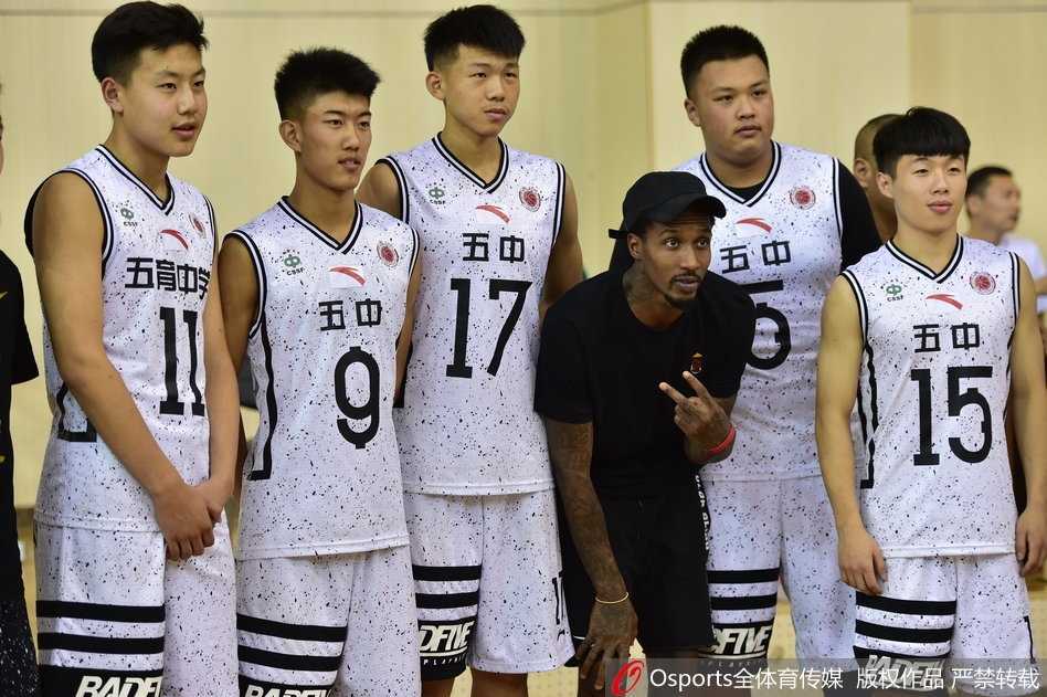 比赛暂停间隙，斯科拉被一群小球员团团围住索要签名，他半蹲着身子尽量与孩子们平视，认真地在本子上签下名字，这一幕让人倍感温馨。