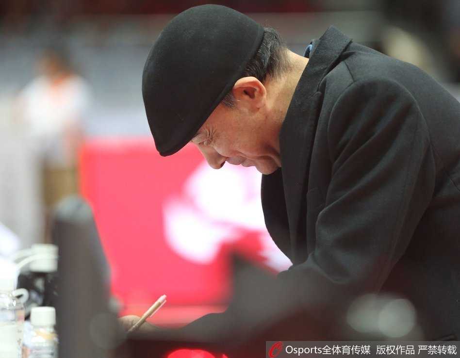 比赛暂停期间，八一队主教练阿的江手持战术板，神情严肃地向围拢在身边的球员们布置最后的战术。