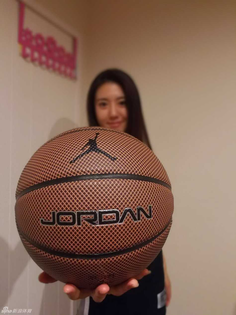 一位穿着复古马刺球衣的年轻球迷，坐在沙发上看电视直播，神情专注而紧张，茶几上摆满了零食和一瓶啤酒，仿佛身临其境。