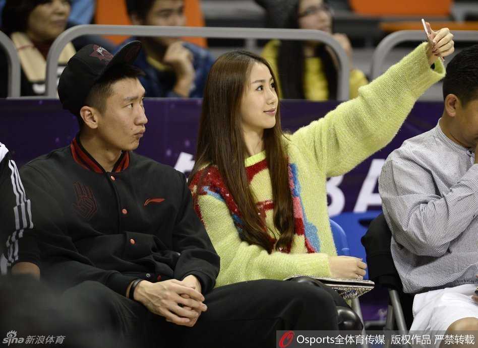 新郎孙悦和妻子陈露在婚礼间隙开心玩起自拍，陈露手举手机，孙悦则对着镜头做出搞怪表情，背后是喜庆的婚礼现场布置，气氛欢快活泼。