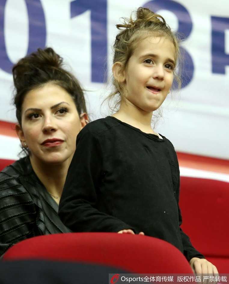 博洛西斯妻子抱着女儿在场边观战，她们穿着温馨的便装，在嘈杂的球馆中为场上的家人默默祈祷。