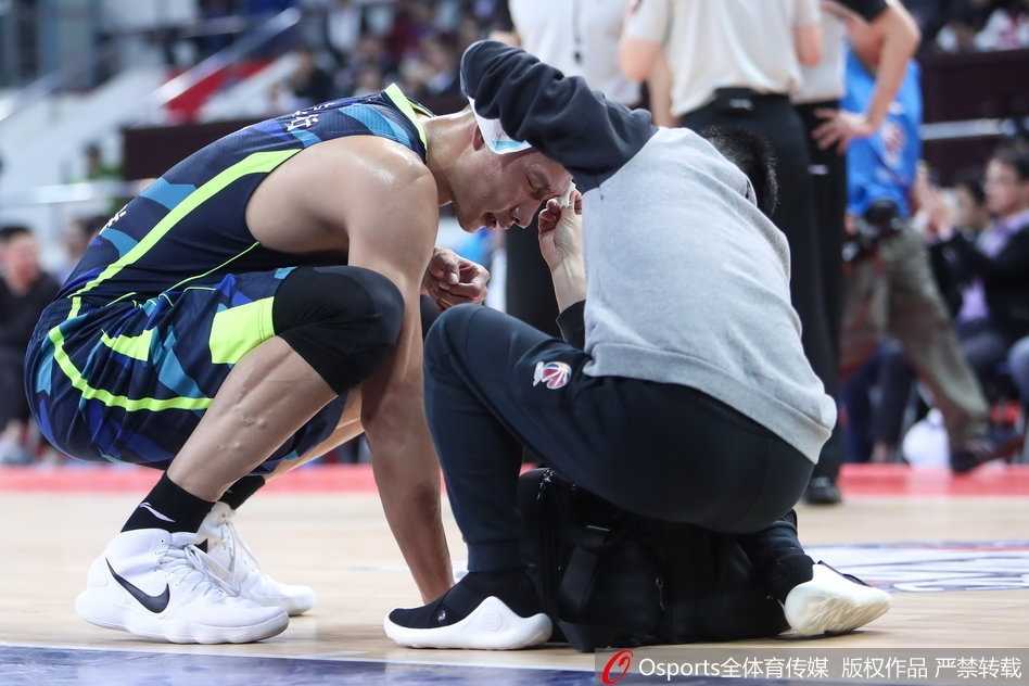 易建联在争抢篮板球瞬间，被对方球员手指不慎戳中右眼，剧痛之下他立即捂住面部，身体蜷曲，表情因疼痛而显得格外狰狞，队医和队友迅速围拢过来查看情况。