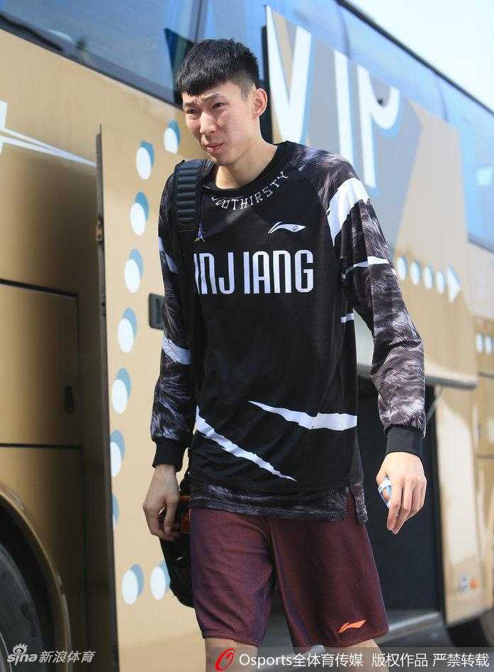 周琦左手拇指缠着厚厚的白色绷带，神情严峻地低头走入训练馆，眼神中透露出忍着剧痛的坚毅与对胜利的渴望。