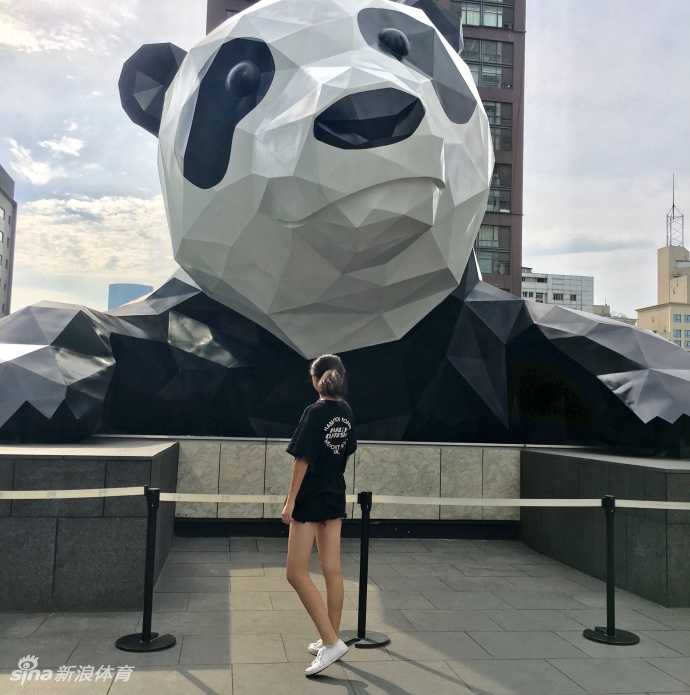 更衣室暖黄的灯光下，鲁西西ii轻倚衣柜，库里球衣搭配休闲短裤，不经意间展现出运动后的惬意与慵懒