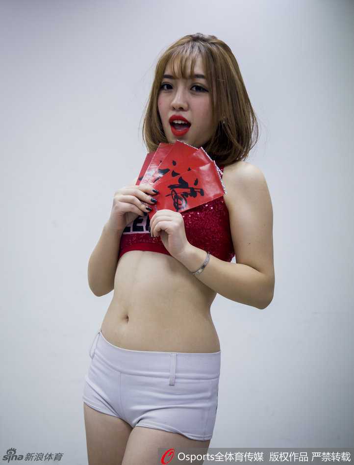 两位宝贝一起展示一幅精致的对联，上联是‘新春快乐’，她们眼中带着笑意，仿佛正在对镜头前的每一位球迷说出这句吉祥话