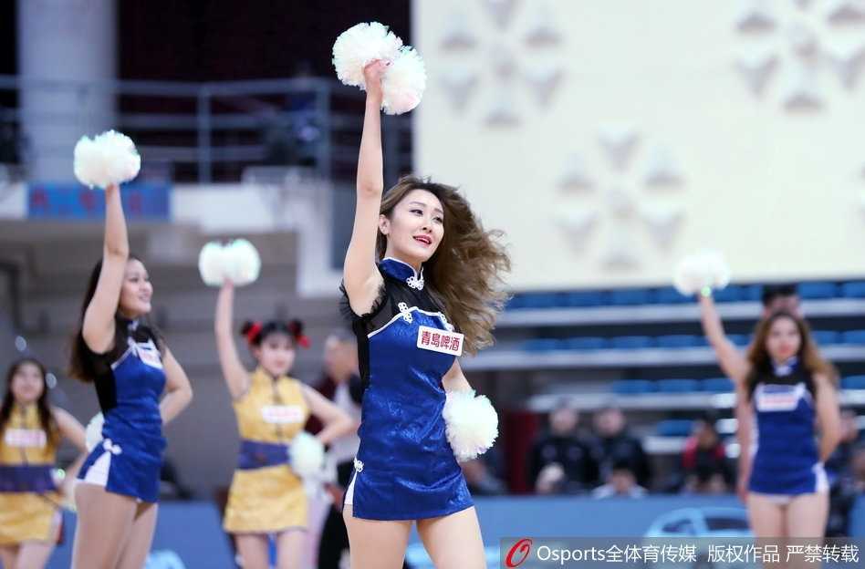 镜头特写一位拿着金色花球的篮球宝贝，她笑容灿烂露出洁白的牙齿，额前的碎发被汗水微微打湿，更显其在舞蹈中的投入与敬业精神