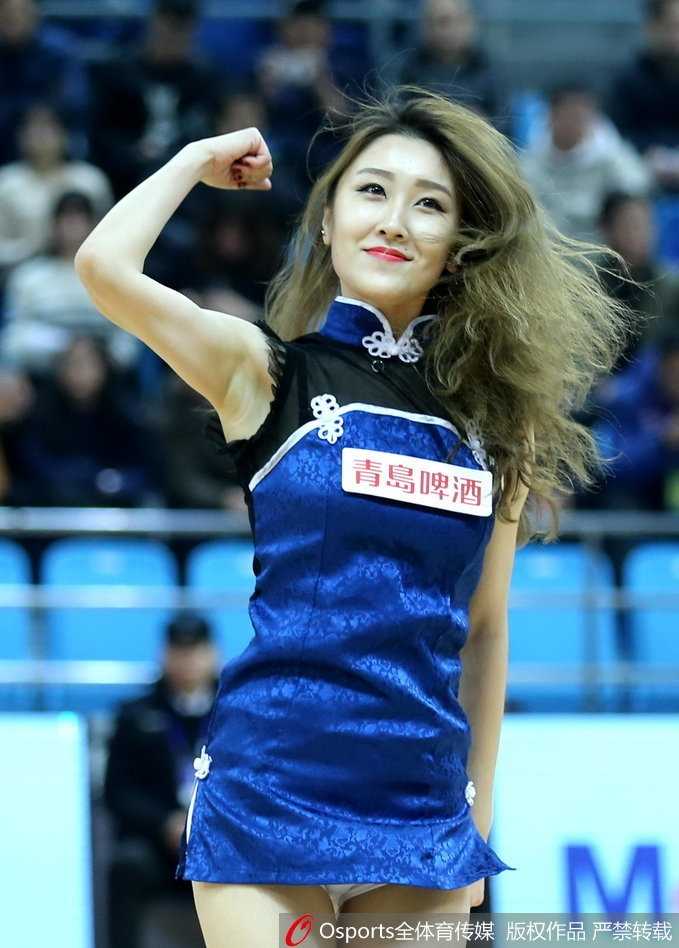 中场休息时，一名篮球宝贝与青岛队的吉祥物进行趣味互动，她弯腰扶着吉祥物的手臂，调皮的神情配合吉祥物的憨态可掬，引得看台上的小观众哈哈大笑