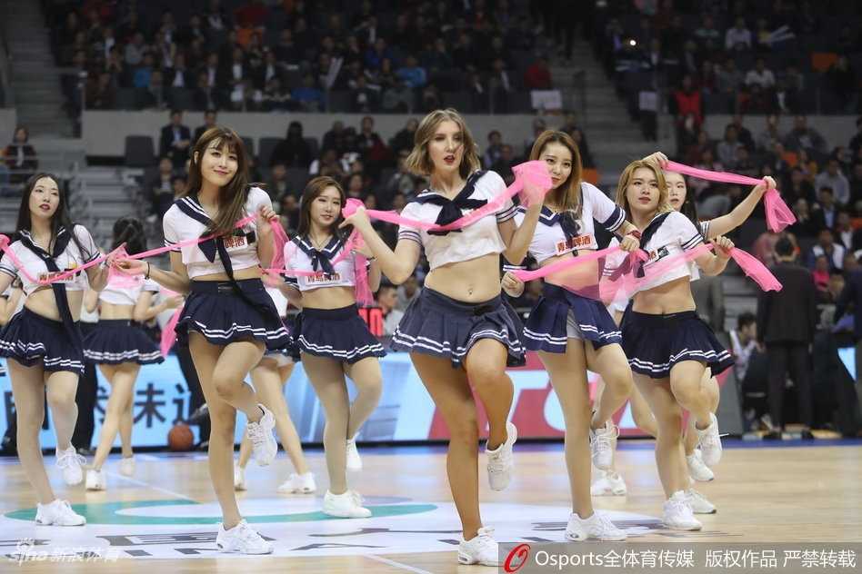 近景画面中，领舞的队员笑容甜美，手中舞动着彩色花球，学生服的深色领带与白色衬衫形成鲜明对比，将少女的活力与优雅平衡得恰到好处。