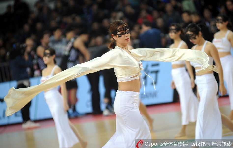 赛场上，篮球宝贝们手持花球摆出帅气pose，面具在聚光灯下闪烁着金属质感的光芒。