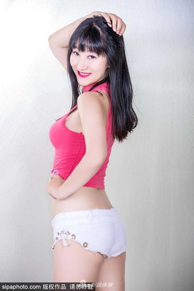 宝贝侧身站立手扶发丝，身形曲线优雅动人，背景虚化中更显主角的明艳与大气