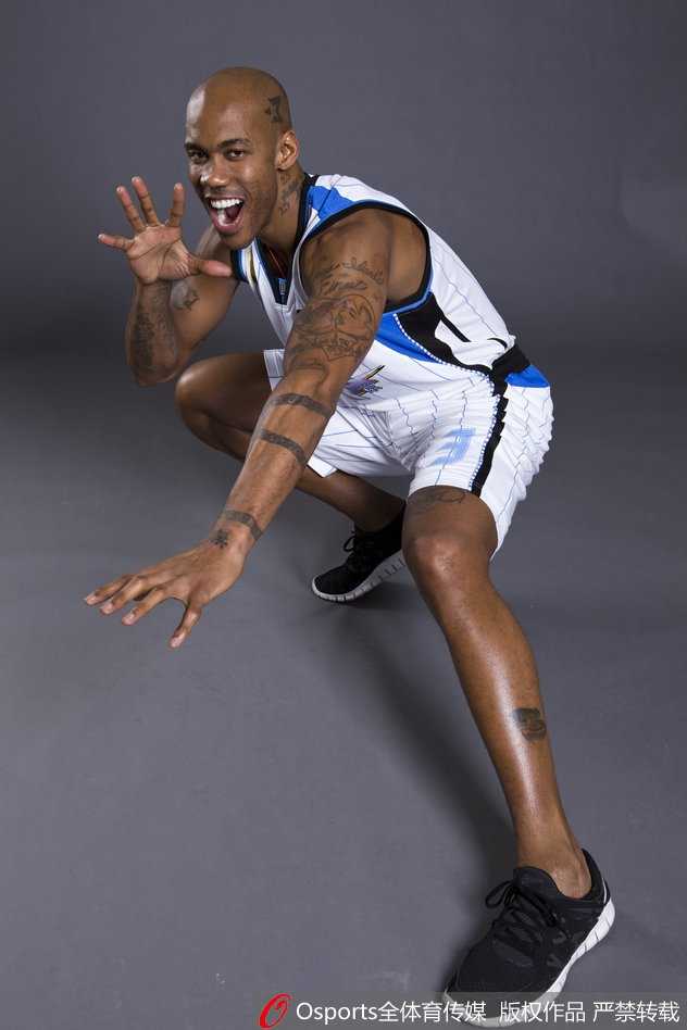 马布里双手抱胸，表情严肃，仿佛在球场上指挥战术，身后是一面挂满他职业生涯经典照片的照片墙，每一张都是荣耀的见证。