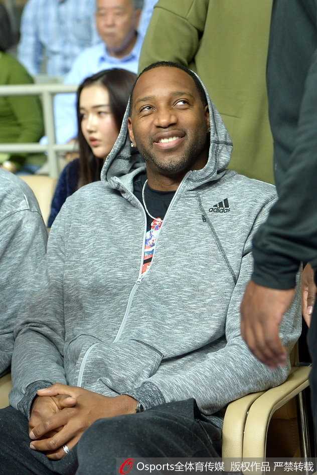 麦蒂露出轻松愉快的笑容，眼睛弯成好看的弧度，似乎在和身边的人谈论着场上某个精彩的回合，心情十分放松。