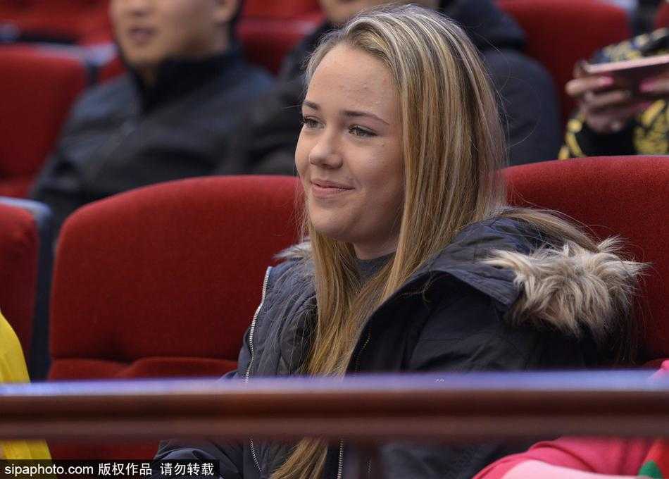 她安静地坐在看台上，即使周围喧嚣四起，眼神中也透着一股对比赛的专注与思索，仿佛在用自己的方式解读着场上的每一次攻防转换。