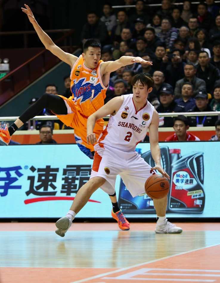 丁彦雨航在对手长臂干扰下自信出手，篮球划过济南夜空飞向篮筐