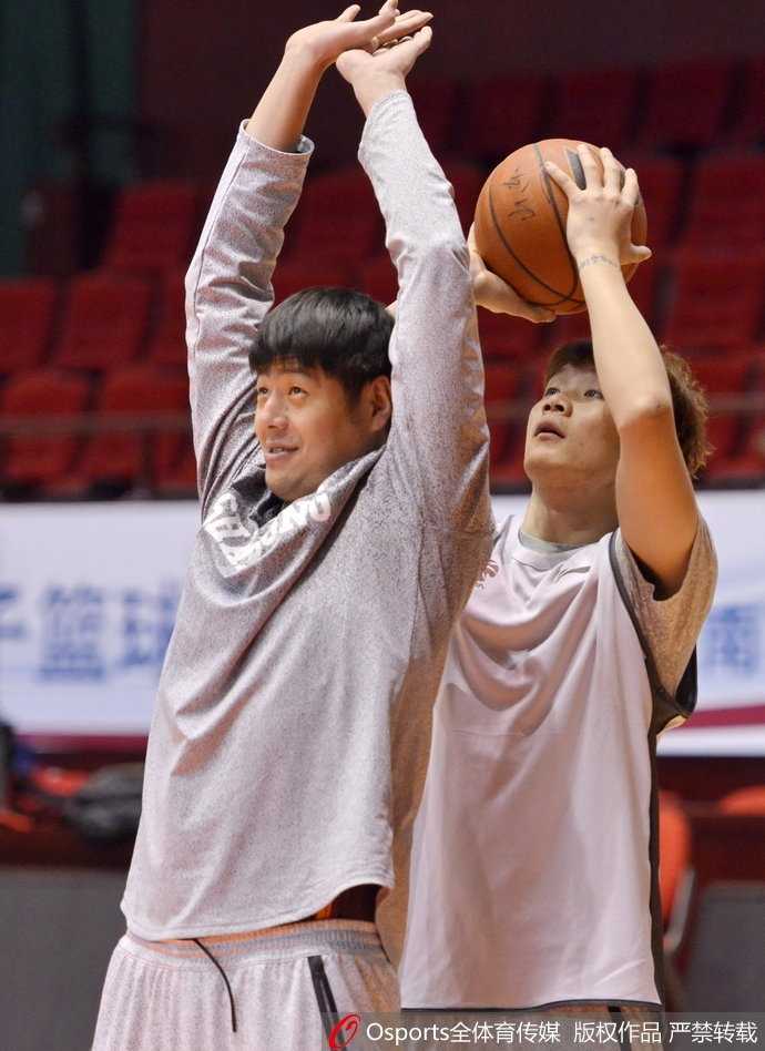 丁彦雨航在训练中单手抓球，脸上带着狡黠的笑容，眼神里透露出轻松与自信，搞怪本色显露无疑。