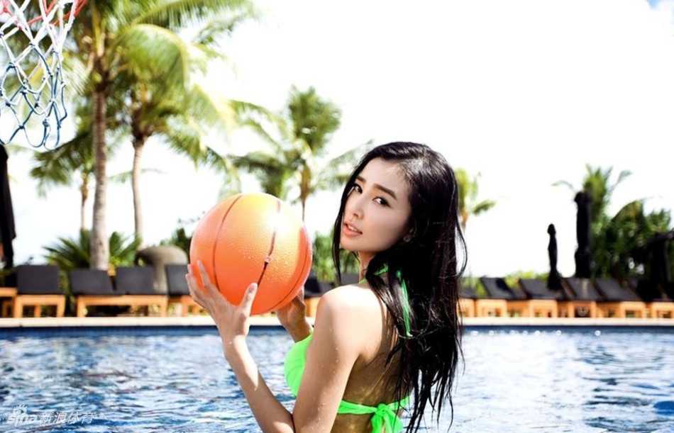 姚星彤在水中篮球场上展现出活力四射的一面，湿发贴额，眼神坚定，尽显运动之美。