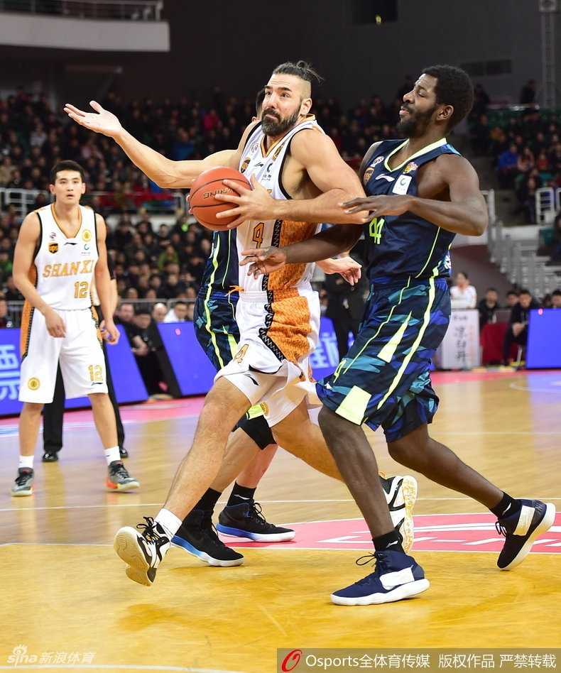 易建联在山西队三人合围之下高高跃起，一双长臂在空中划出满弓，指尖轻拨将篮板球稳稳揽入怀中，眼神中透露出不容侵犯的王者霸气。