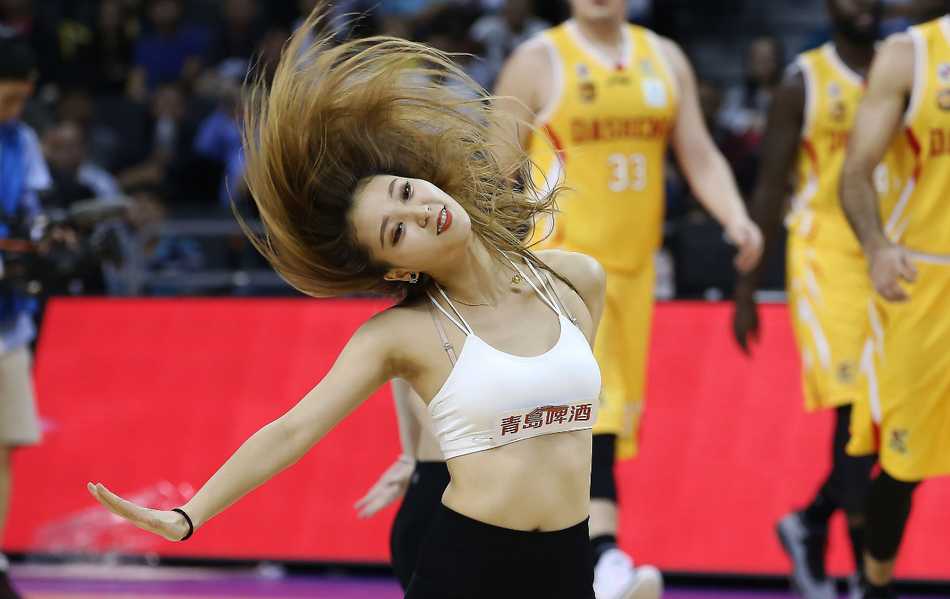 镜头特写一位正在热舞的篮球宝贝，精致的妆容和专注的神情，透露出她对这份舞台的热爱与敬业。