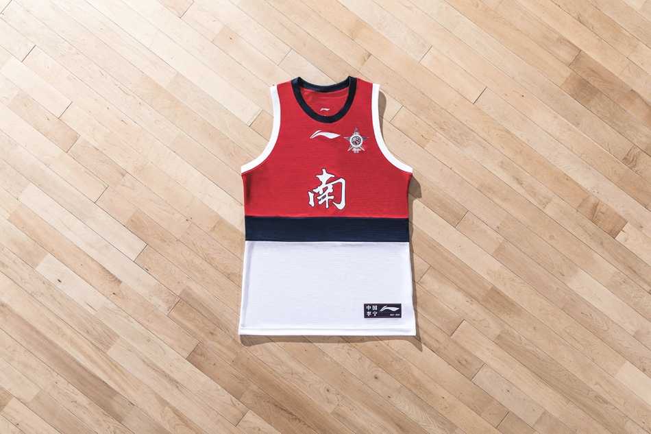 🏆燃情鹏城,荣耀装备!回顾2018年CBA全明星周末的南征北战与时尚风暴🏀 身披南区全明星专属热身T恤的孟铎在场边蓄势待发,红白的配色映衬着他自信的笑容,这件装备注定要在聚光灯下见证南区的荣耀时刻。